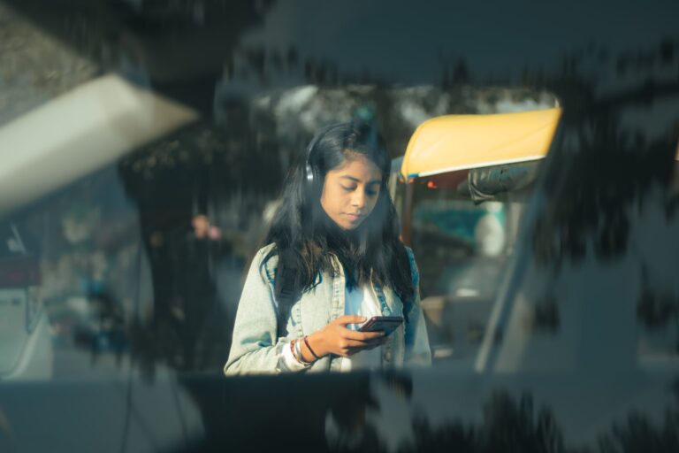 A woman using a smartphone on a street in New Delhi