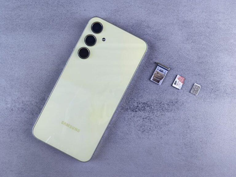 A smartphone with SIM tray and memory card on a neutral background