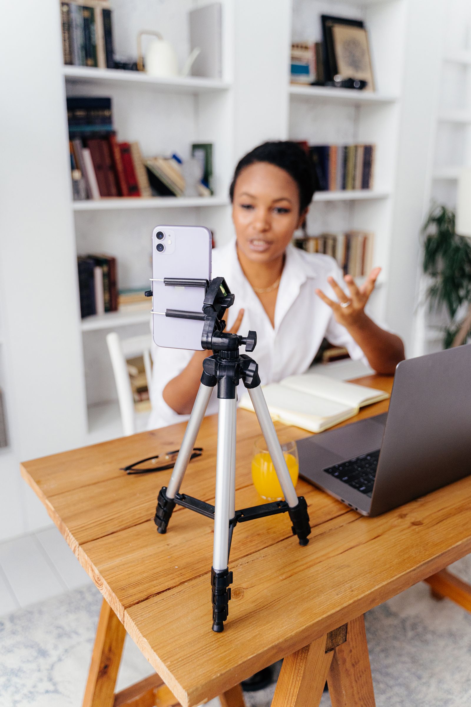 A woman recording with a smartphone mounted on a tripod